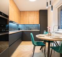 A kitchen in a 3-room apartment with a wooden decor floor and a dining table.