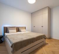 Bedroom in a 3-room apartment with a bed, built-in wardrobe, and floor with wood decor.