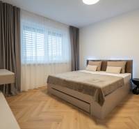 Bedroom in a 3-room apartment with a bed and wooden decor flooring.