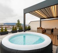 Rooftop terrace of a 3-room apartment on Kožušnícka Street in Trenčín with a hot tub and seating area.