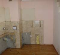 A two-room apartment with wooden decor flooring, ready for renovation and kitchen installation.