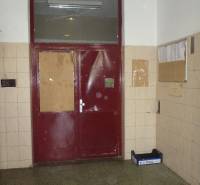 Entrance to the building of the two-room apartment on Stavbárska Street in Bratislava - Vrakuňa with red doors.