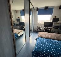 A bedroom in a 3-room apartment with a work corner and built-in wardrobes.