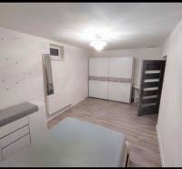 A bedroom with white furniture and a wood-patterned floor in a family house.
