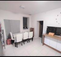 Dining room in a family house with a large clock and upholstered chairs.