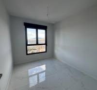 An empty room in a 3-room apartment with a marble floor and a large window.