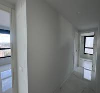 A hallway in a 3-room apartment with white walls and a glossy floor.