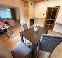 Dining area with a solid wood table, fireplace, and wooden decor flooring in a family house.