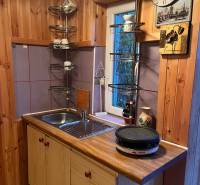 A kitchen in a family house with wooden paneling and a sink, time to cook.