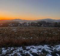 Sunset over a snowy landscape and family houses in Tvrdomestice.