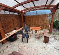 A shelter in the garden of a family house in Tvrdomestice, with wooden elements and furniture.