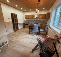 A kitchen in a family house with a wooden decor floor and a dining table.