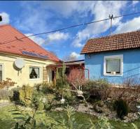 A family house in Tvrdomestice with two colorful houses, a garden, and a solar panel.