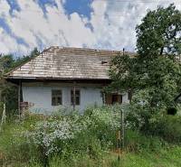 A family house in Nenince with a grassy plot, a fence, and trees in the garden.