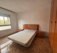 A bedroom in a 4-room apartment with a double bed and a floor with a wood decor.