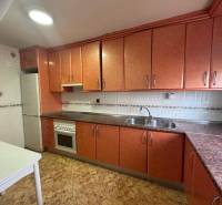 A kitchen in a 4-room apartment with orange cabinets and white accessories.