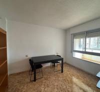 Interior of a 4-room apartment with a wooden decor floor and a table by the window.