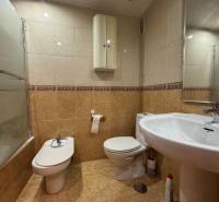 A bathroom in a 4-room apartment with a bathtub, bidet, and tiled floor.