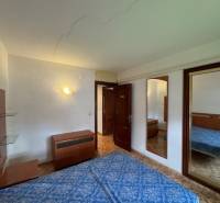 Bedroom in a 4-room apartment with wood-patterned flooring, built-in wardrobes, and a double bed.