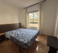 Bedroom in a 4-room apartment with a window and a wooden decor floor.