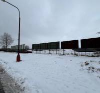 A snowy plot in Poprad with commercial spaces and abandoned advertising panels.