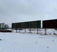 Snow-covered commercial spaces in Poprad with a row of empty advertising billboards on a snowy area.