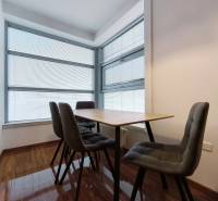 Dining room with a table and chairs in a two-room apartment, floor with wooden decor.
