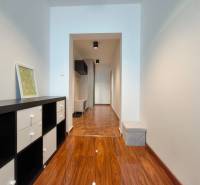 Entrance hall of a 2-room apartment with a wooden decor floor and furniture.