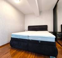 Bedroom in a 2-room apartment with a comfortable bed and wardrobe, floor with wooden decor.