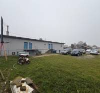 Parking lot with cars and an industrial building on Bratislavská Street in Veľký Biel. Land - residential.