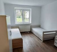 A bright interior in a 2-room apartment with two beds and a floor with a wooden decor.