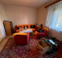 Living room in a family house with carpets and comfortable seating.