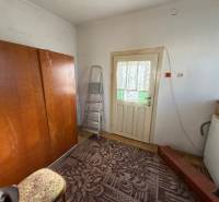 A room in a family house with a carpet, a wooden wardrobe, and a ladder.