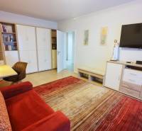 Living room in a 4-room apartment with a comfortable sofa, television, and a work desk.