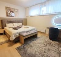 A bedroom with a bed, a mirror, and decorative rugs in a 4-room apartment.