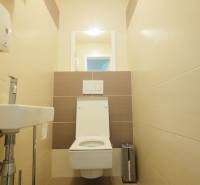 A bathroom with light ceramic tiles and a smaller sink in a 4-room apartment.