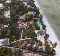 Aerial view of coastal bungalows and villas in Paje, Zanzibar South East, overlooking the ocean.