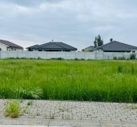 Land for residential use in the Hviezdoslavov area, Podháj, with green grass and neighboring houses.