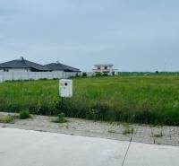 Plots - housing on Podháj Street in Hviezdoslavov, grass and residential buildings in the background.