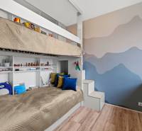 Children's room with a bunk bed, stairs, and shelves, floor with wooden decor.