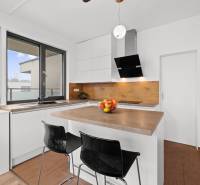 Bright kitchen with an island and appliances, 3-room apartment, floor with wood decor.