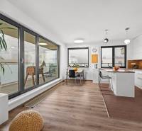 A kitchen in a 3-room apartment with windows and a wooden decor floor.