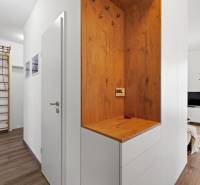 A hallway in a 3-room apartment with a ribbed wall and a floor with a wooden decor.