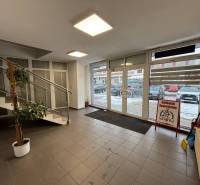 Interior of an office with tiling, a staircase, and glass doors.