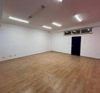 Spacious offices with wood-patterned flooring and white walls.