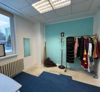 Room in offices with a coat rack, mirror, and blue wall.