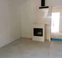 A room in a family house with a fireplace and a simple floor without decor.