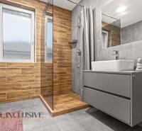 A bathroom with a wood-patterned floor in a 3-room apartment, includes a shower and a cabinet.
