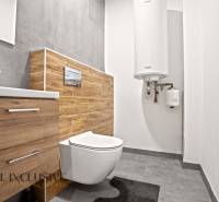 Bathroom in a 3-room apartment with a wooden decor floor and modern fixtures.