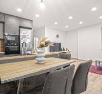 A kitchen in a 3-room apartment with a wooden decor floor and a dining table.